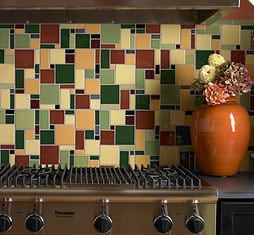 A jumbled pattern of contrasting decorative tiles makes this backsplash a focal point in the kitchen.