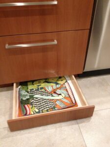 Toe-kick drawer offers flat storage for potholders, placemats, and more.