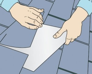 Man's hands lifting the damaged shingle, slipping a sheet metal flashing underneath.