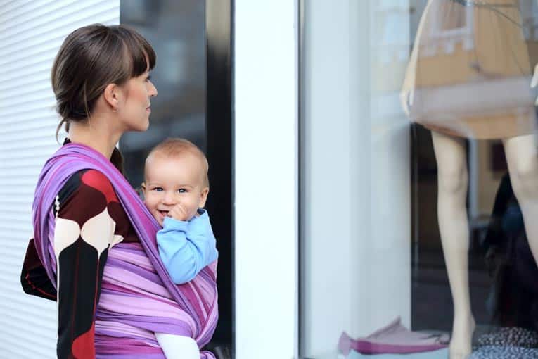 Sling-style baby carrier can be worn with baby either in front or back.