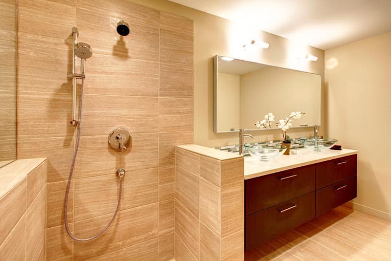 Wall-mounted cabinets contrast beautifully with this stone shower. 