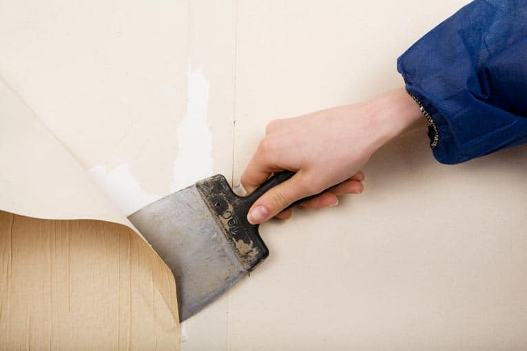 It's easy to remove old, loose wallpaper with a large putty knife.