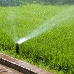 popup sprinkler watering lawn