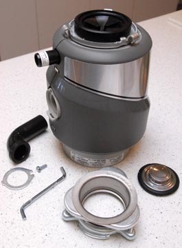 A garbage disposer unit, including its components placed on a countertop.