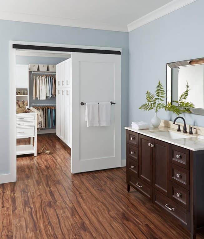 White sliding barn door, leading from a bathroom into a closet.