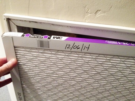 New replacement filter inserted, with date marks and arrows pointing to ductwork.