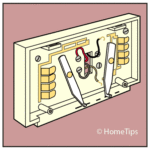 Diagram of an electronic thermostat’s base including colored wires and terminal screws.