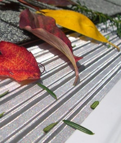 A stainless-steel, micro-mesh gutter screen in ribbed design, blocking the fallen leaves.
