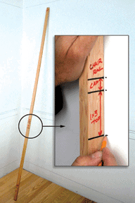 A long wooden pole with markings, used for measurements against a wall.
