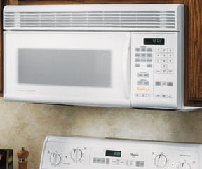 A white over-the-range microwave oven, fitted into an upper cabinet.