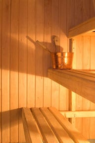 Light-colored wooden benches inside a sauna.