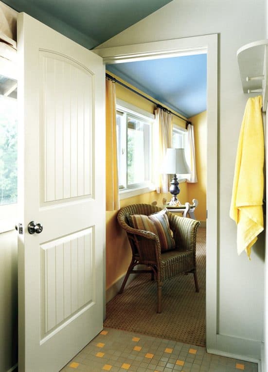 Wide-open white composite door, leading from a bathroom into a bedroom.