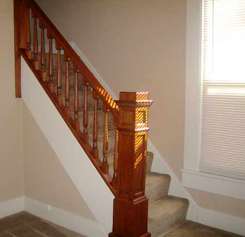 carpeted staircase with wood rail