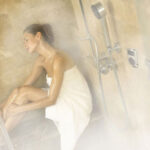 Woman sitting inside a steam shower room.