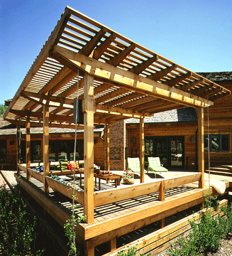 Detached backyard patio deck with a pergola roof.