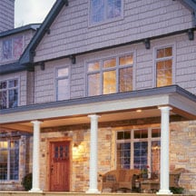 Stately wooden columns support the roof of this front porch.