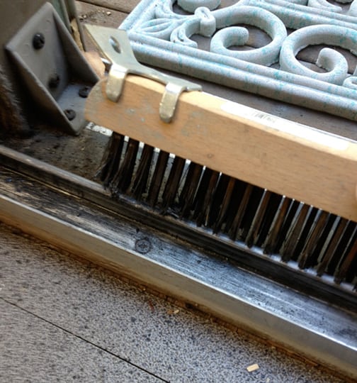 A sliding door’s track cleaned with a wire brush. 
