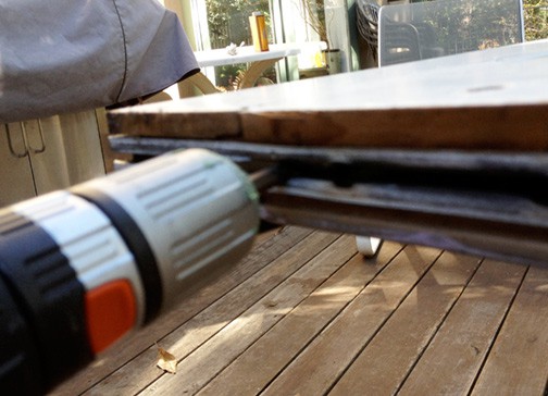 Screwdriver's tip inserted between a rubber weatherstripping of a sliding door's edge.