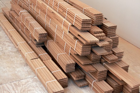solid-hardwood-flooring Pile of light hardwood flooring planks.