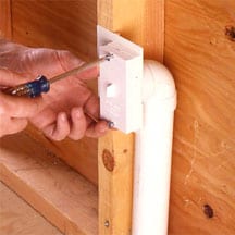 Man's hands screwing a pipe outlet cover.