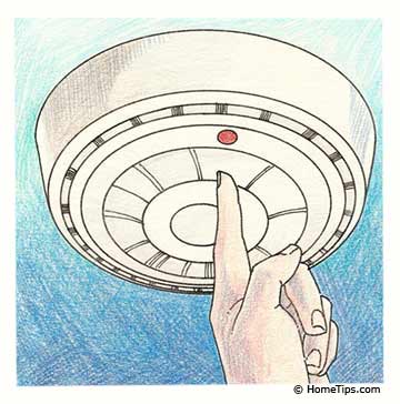 Illustration of a finger pressing the red button on a ceiling-mounted smoke detector.