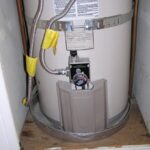 A water heater drip pan installed beneath a storage water heater.