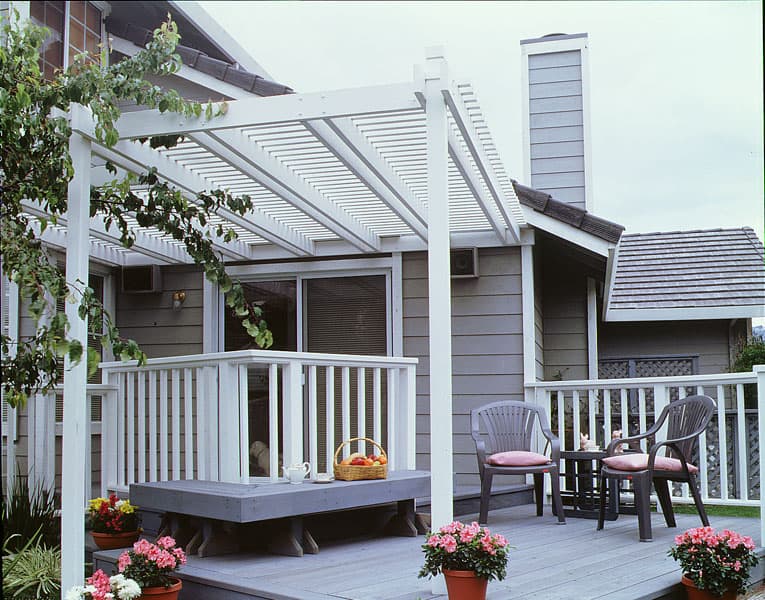 A white painted wood patio cover over a new deck.