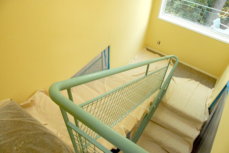 A yellow drop cloth lining a stairway's carpeted floor. 