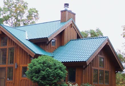 Cottage house including a chimney with blue galvanized steel metal roofing.