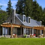 A modern forest home with grey standing seam metal roof.