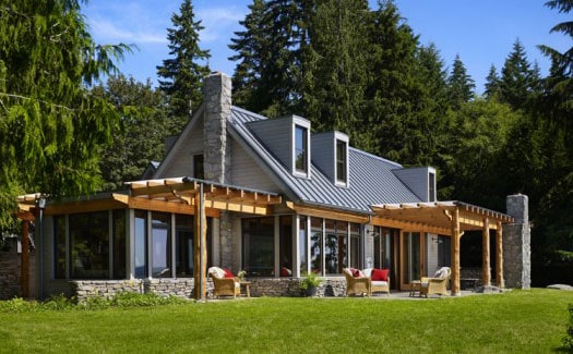 A modern forest home with grey standing seam metal roof.