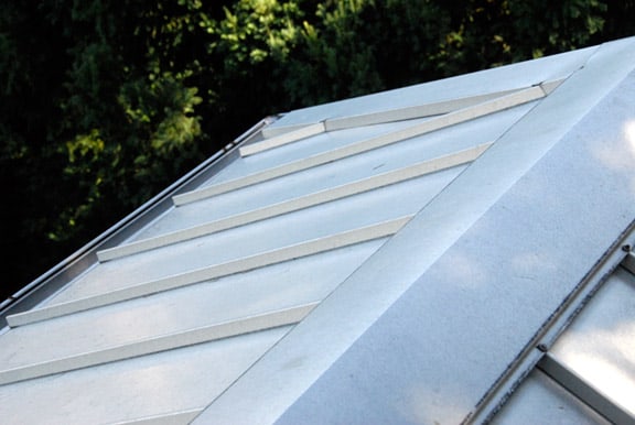 An installed section of light grey sheet metal roofing.