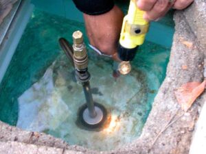 A professional leak detector checks this pool's skimmer—often the source of the problem.