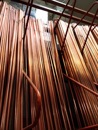Rigid copper pipes in varying thicknesses arranged vertically.
