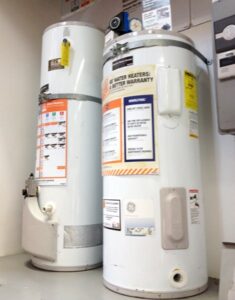 Two tanks of white cylindrical storage water heaters.