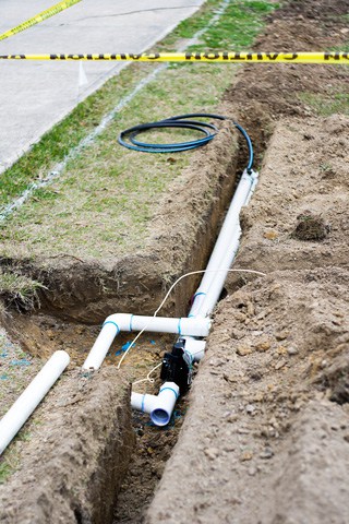 Sprinkler pipes run through narrow, shallow trenches. Photo: © Auntpittypat | Dreamstime