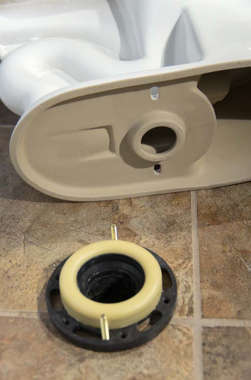 Toilet wax ring and flange secured with bolts on the floor.