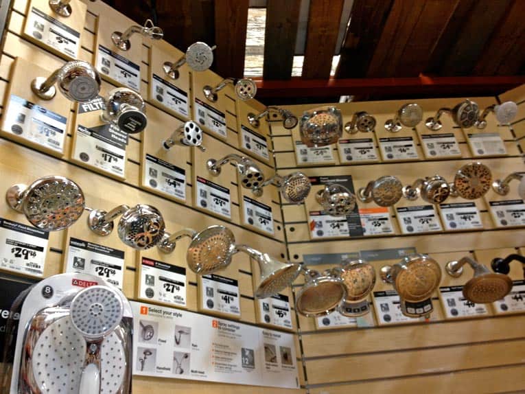 Various types of shower head mounted on a wall display rack.