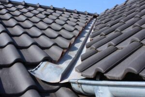 Metal flashing between roof slopes, connecting to a rain gutter.