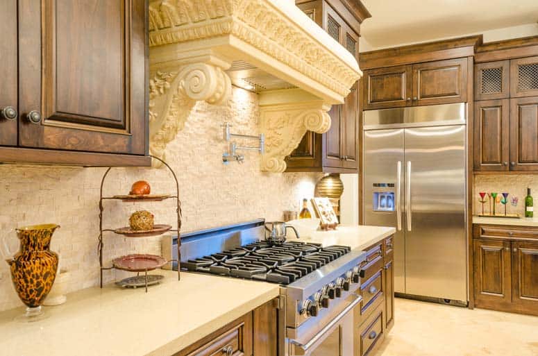 Ornate range hood encloses built-in range equipment. 