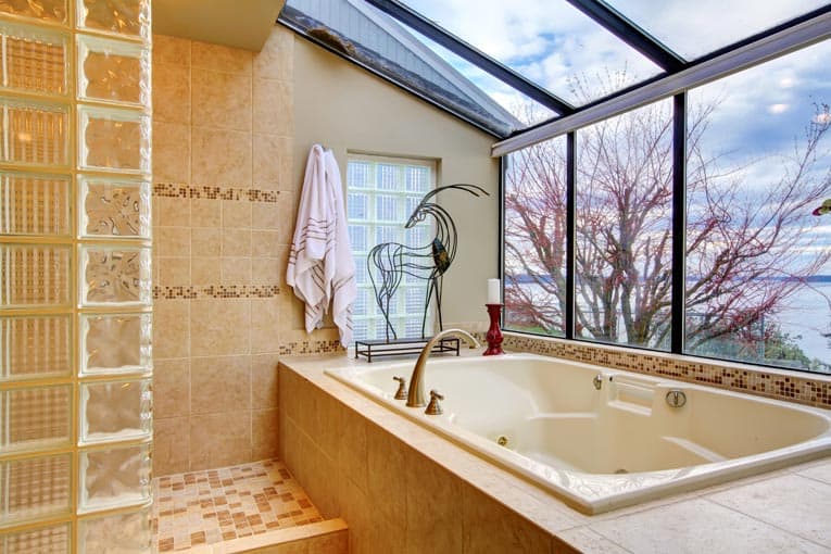 Beach view bathroom with a drop-in tub, including a greenhouse window.