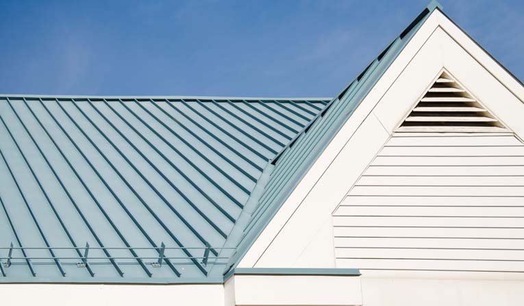 Light blue standing seam metal roofing including white triangular gable roof vent.