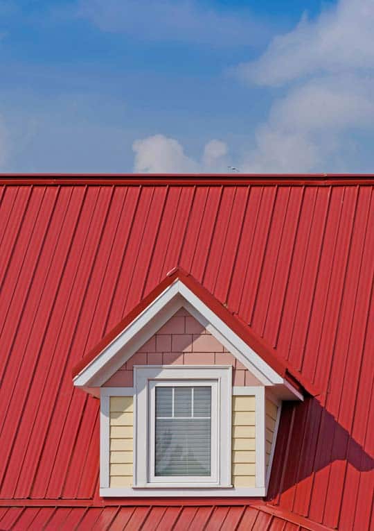 Red standing-seam metal roofing including a gabled dormer.