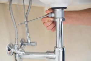 The pivot rod beneath the sink connects the pop-up to the sink-top lever.