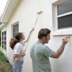 painting house with roller and brush