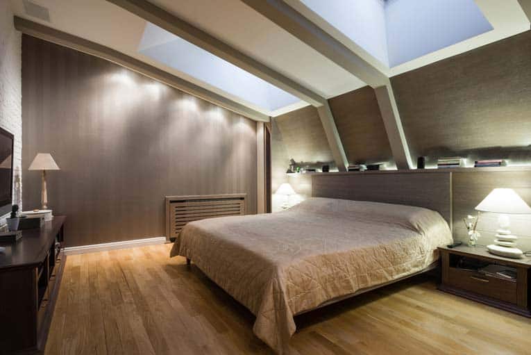 An attic bedroom with large dual skylights.