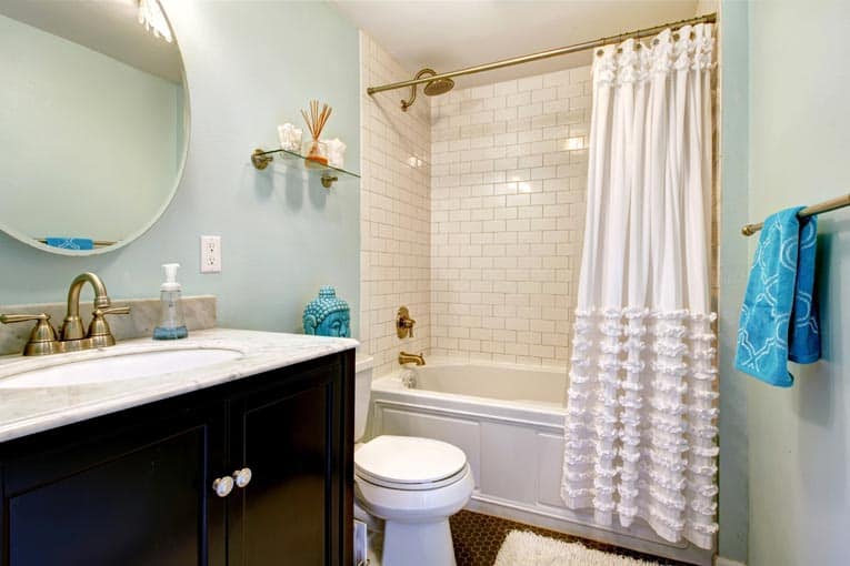 A conventional small bathroom with a white alcove tub shower.