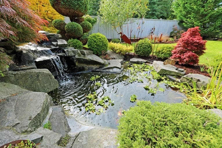 Garden pond and waterfall add beauty and tranquility to this backyard.