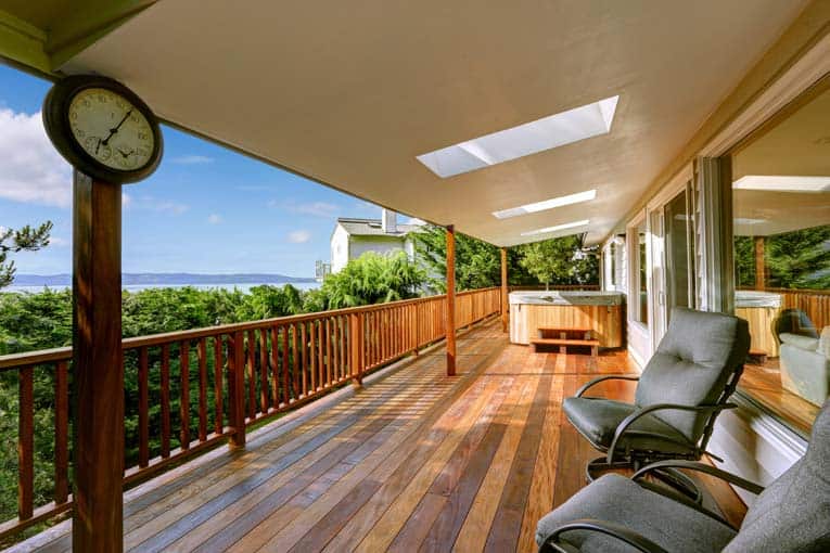 A covered wooden deck, brightening a veranda with 3 skylights.