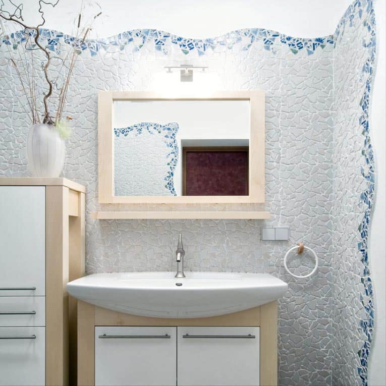 Custom mosaic walls give this powder room artistic charm.